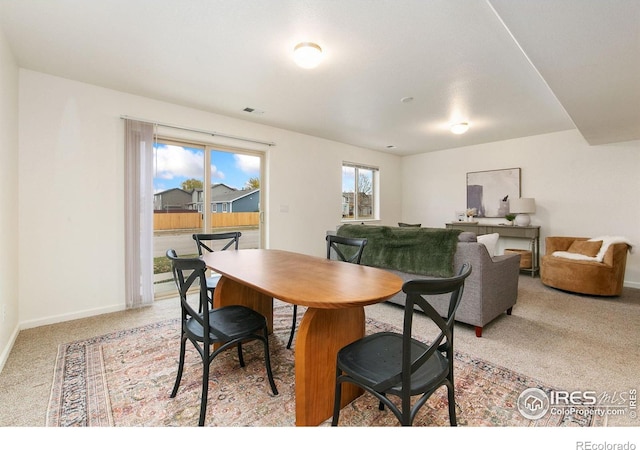 carpeted dining area with a wealth of natural light