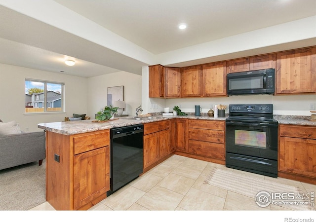 kitchen with light tile patterned floors, black appliances, sink, and kitchen peninsula