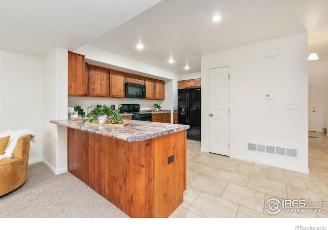 kitchen featuring kitchen peninsula and black appliances