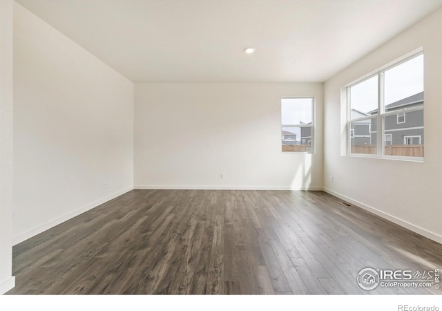 empty room with dark hardwood / wood-style flooring