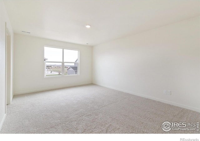 spare room featuring light colored carpet