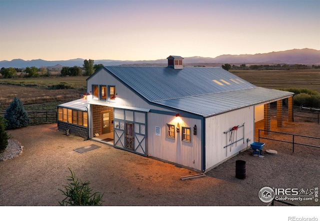 view of front of house featuring a mountain view and an outdoor structure