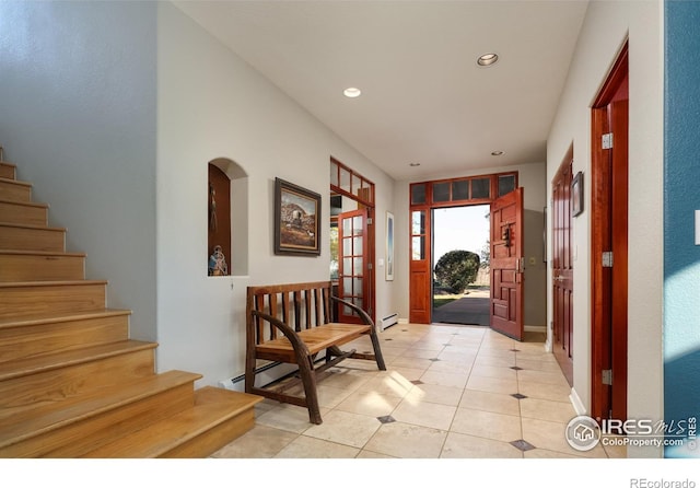 tiled entryway with a baseboard heating unit