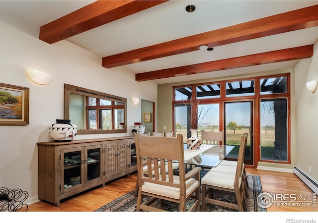 dining space with a baseboard heating unit, beam ceiling, and light wood-type flooring