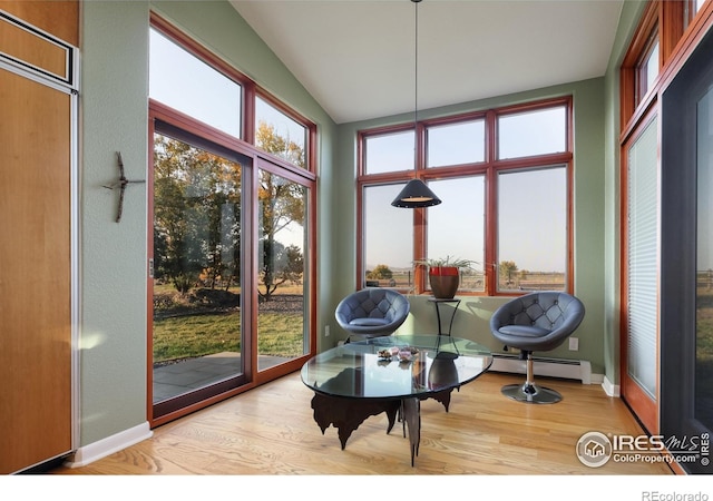 sunroom / solarium featuring a baseboard radiator and vaulted ceiling