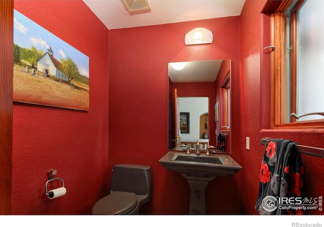 bathroom with a textured ceiling and toilet