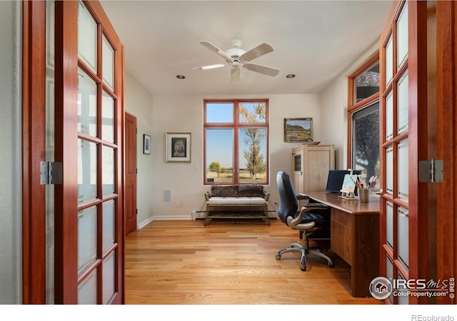 office space featuring a baseboard radiator, light hardwood / wood-style flooring, and ceiling fan