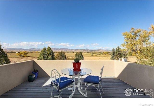 deck with a rural view and a mountain view