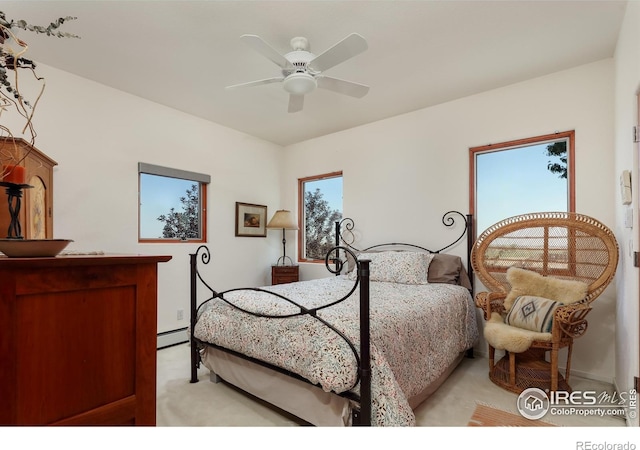 carpeted bedroom with a baseboard radiator and ceiling fan