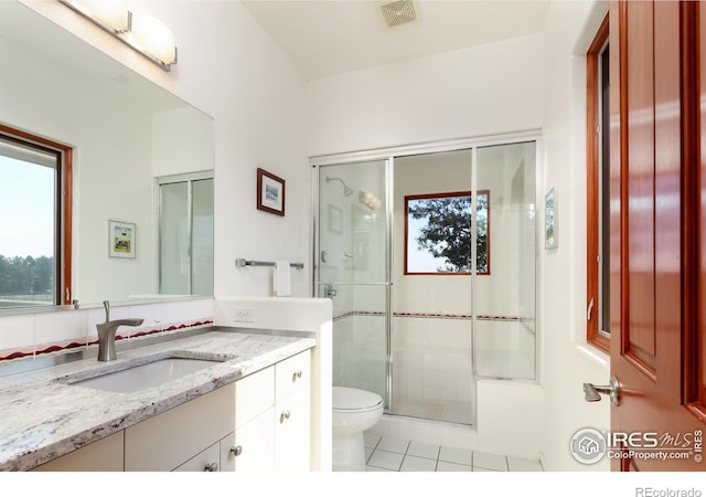 bathroom with toilet, an enclosed shower, vanity, and tile patterned flooring