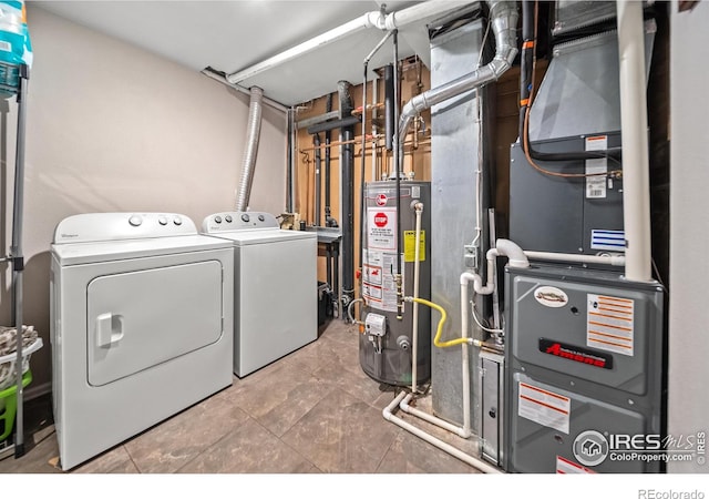 clothes washing area featuring gas water heater, washing machine and clothes dryer, and heating unit