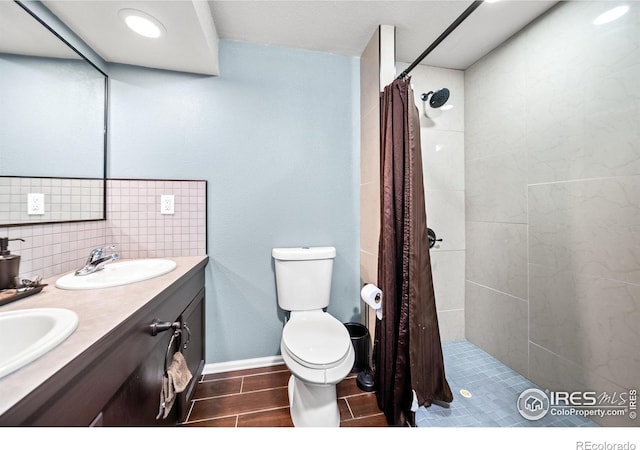 bathroom featuring vanity, toilet, tasteful backsplash, and curtained shower