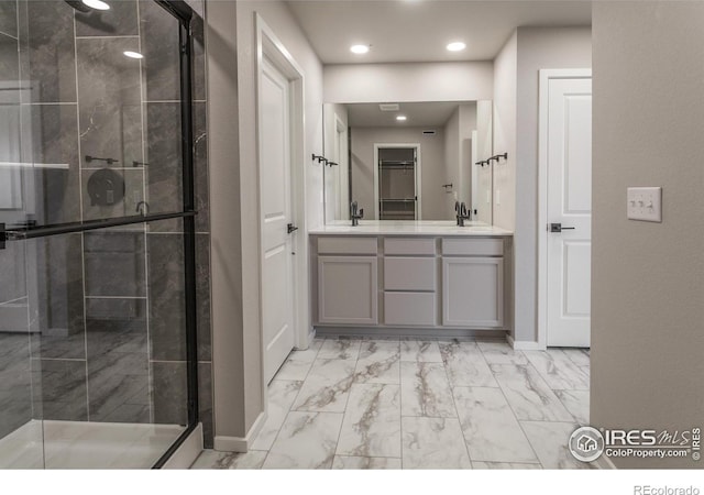 bathroom featuring a shower with door and vanity