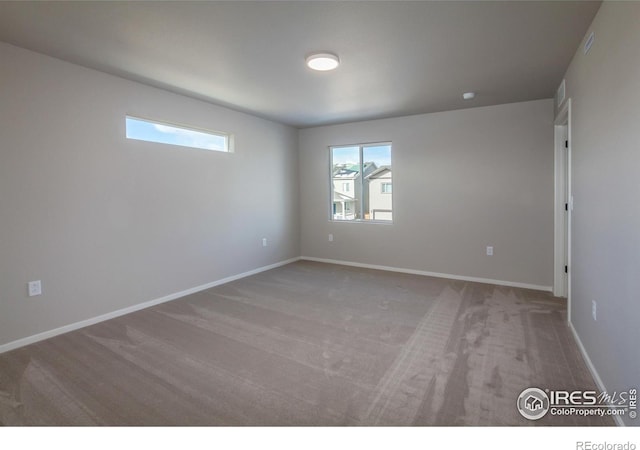 unfurnished room with carpet flooring and a wealth of natural light