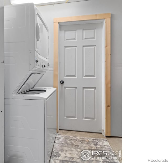 clothes washing area featuring stacked washer / dryer