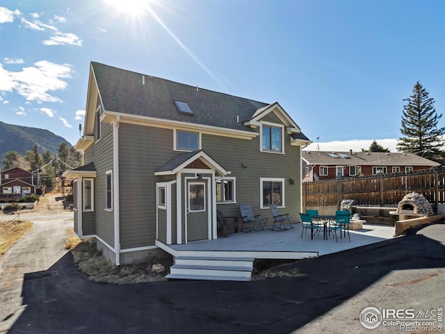 rear view of property with a patio and a mountain view