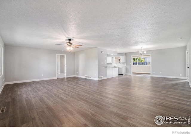 unfurnished living room with dark wood-type flooring, a textured ceiling, and ceiling fan with notable chandelier