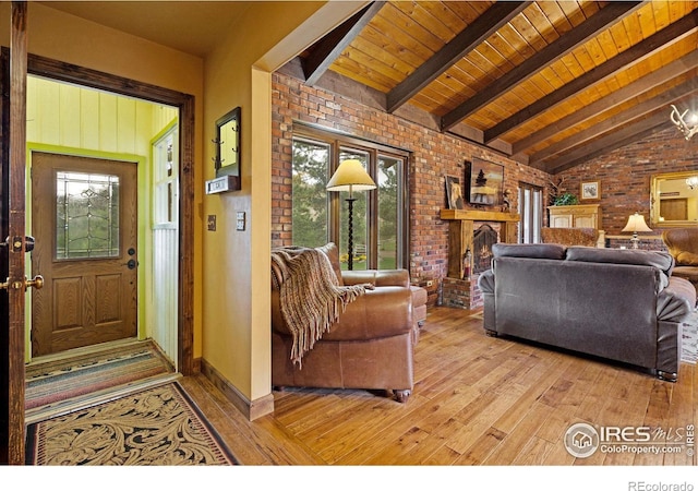 living room with light hardwood / wood-style floors, brick wall, wood ceiling, and lofted ceiling with beams