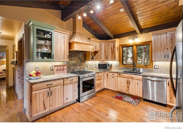 kitchen with light hardwood / wood-style floors, stainless steel appliances, vaulted ceiling with beams, and light brown cabinets