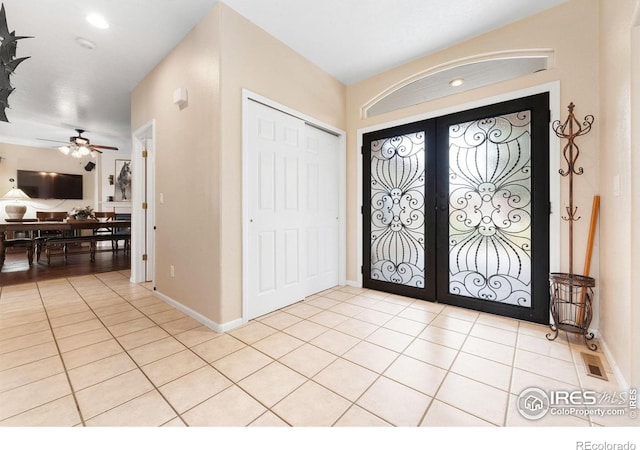 tiled entrance foyer with french doors and ceiling fan