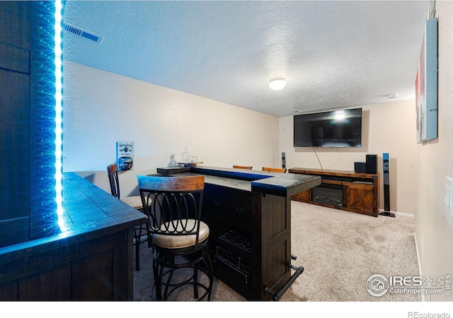 bar with tile counters, carpet floors, and a textured ceiling