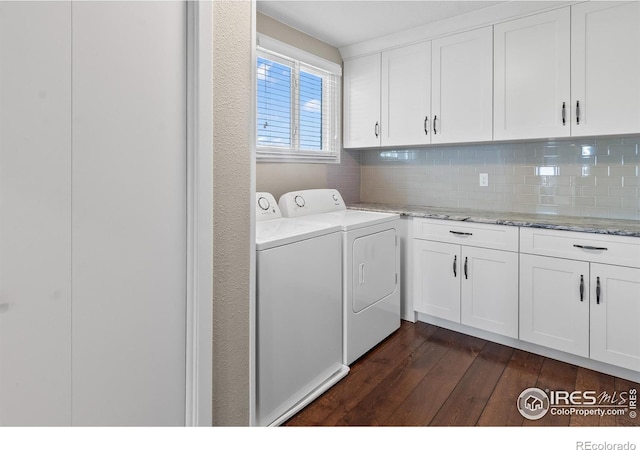 clothes washing area featuring cabinets, washer and dryer, and dark hardwood / wood-style flooring