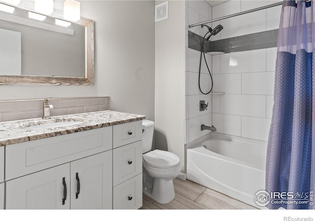 full bathroom with toilet, vanity, and shower / tub combo with curtain