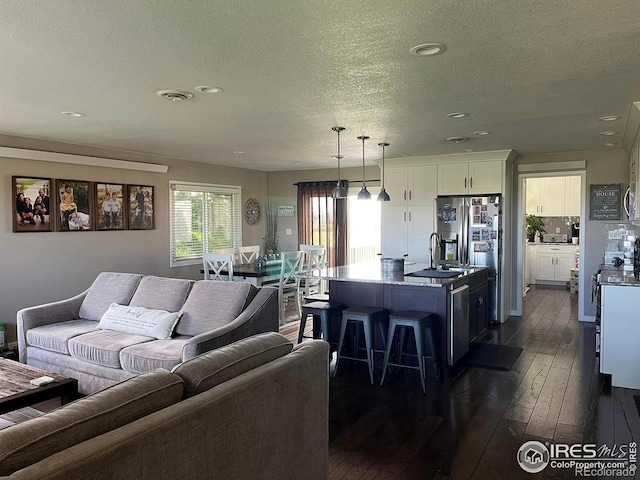 living room with dark wood-type flooring and a textured ceiling