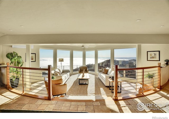 living room with a wall unit AC, a wealth of natural light, and a water view