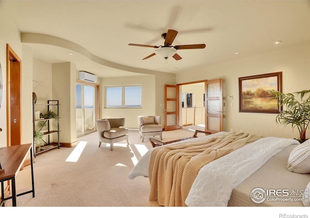 carpeted bedroom featuring a wall mounted AC and ceiling fan