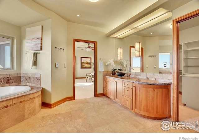 bathroom with tiled bath and vanity