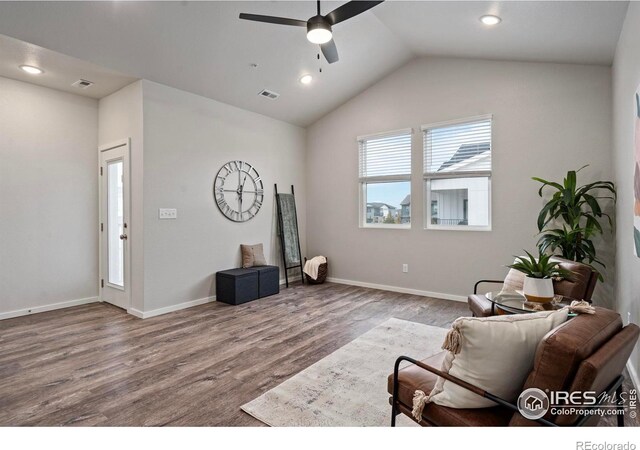 living room featuring hardwood / wood-style floors, vaulted ceiling, and ceiling fan