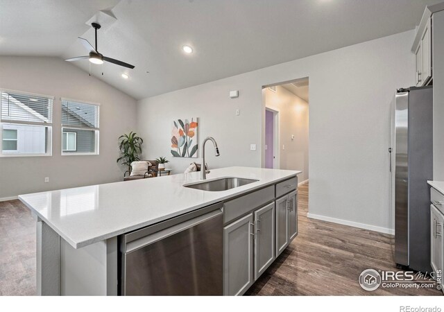 kitchen with stainless steel appliances, sink, a kitchen island with sink, lofted ceiling, and gray cabinets