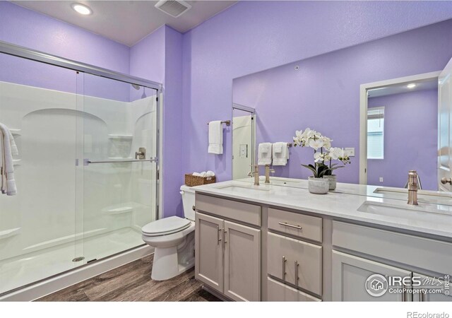 bathroom with toilet, vanity, hardwood / wood-style floors, and walk in shower