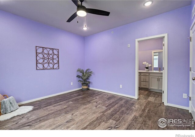 unfurnished bedroom featuring dark wood-type flooring, ceiling fan, sink, and connected bathroom