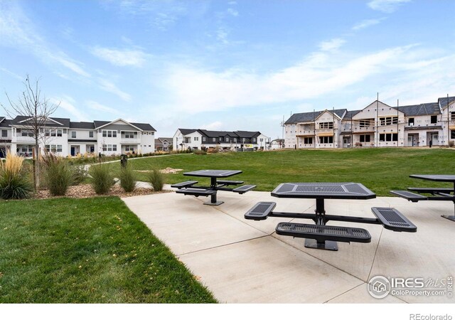 view of home's community featuring a patio and a lawn