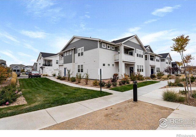 view of home's exterior featuring a lawn and a balcony