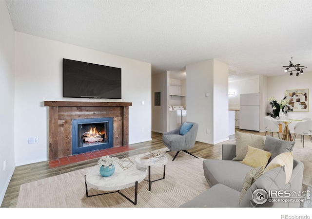 living room with hardwood / wood-style flooring, washing machine and dryer, and a textured ceiling