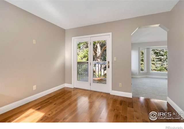 spare room with hardwood / wood-style flooring and a healthy amount of sunlight