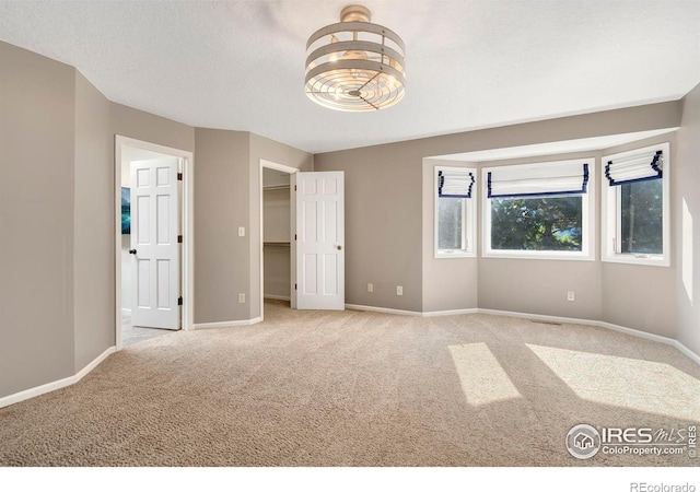 unfurnished bedroom with light carpet and a textured ceiling