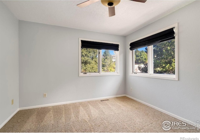 unfurnished room featuring a textured ceiling, carpet flooring, and ceiling fan