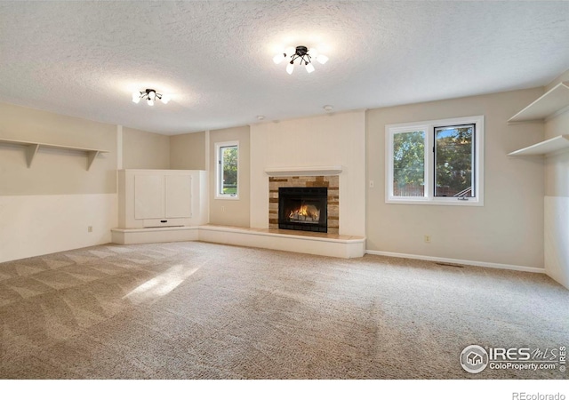 unfurnished living room with a textured ceiling and carpet flooring