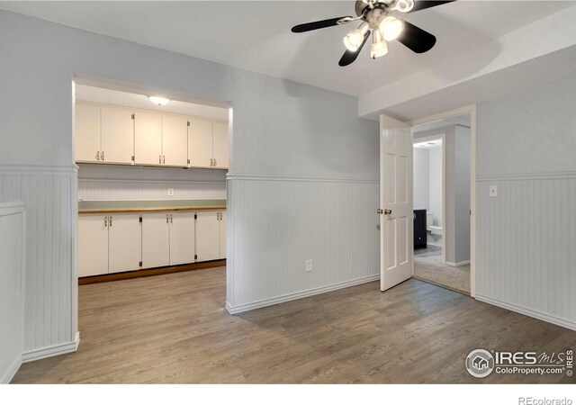 kitchen with light hardwood / wood-style floors, white cabinets, and ceiling fan