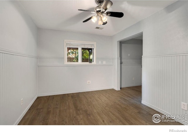 unfurnished room with ceiling fan and dark hardwood / wood-style flooring