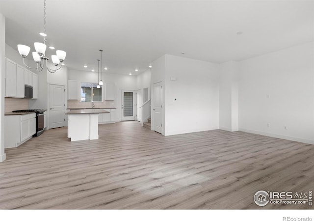 kitchen with light hardwood / wood-style flooring, a center island, white cabinetry, and stainless steel appliances