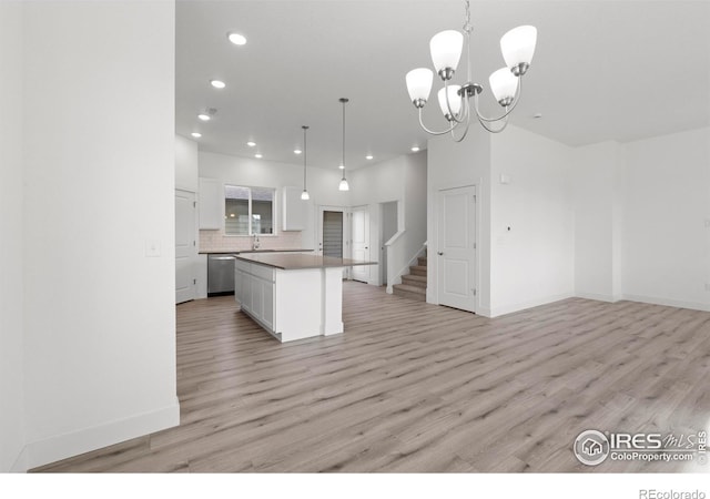 kitchen with a kitchen island, light hardwood / wood-style flooring, decorative light fixtures, and white cabinets