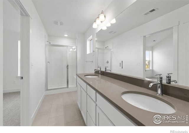 bathroom with vanity, a shower with shower door, tile patterned flooring, and plenty of natural light