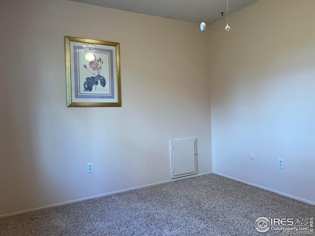 carpeted spare room featuring a textured ceiling