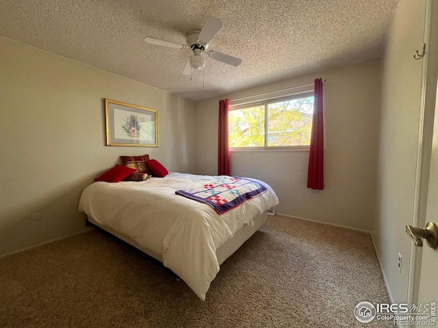 bedroom with a textured ceiling, dark colored carpet, and ceiling fan