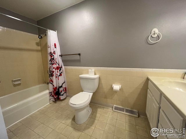 full bathroom with tile walls, tile patterned floors, vanity, toilet, and shower / tub combo with curtain